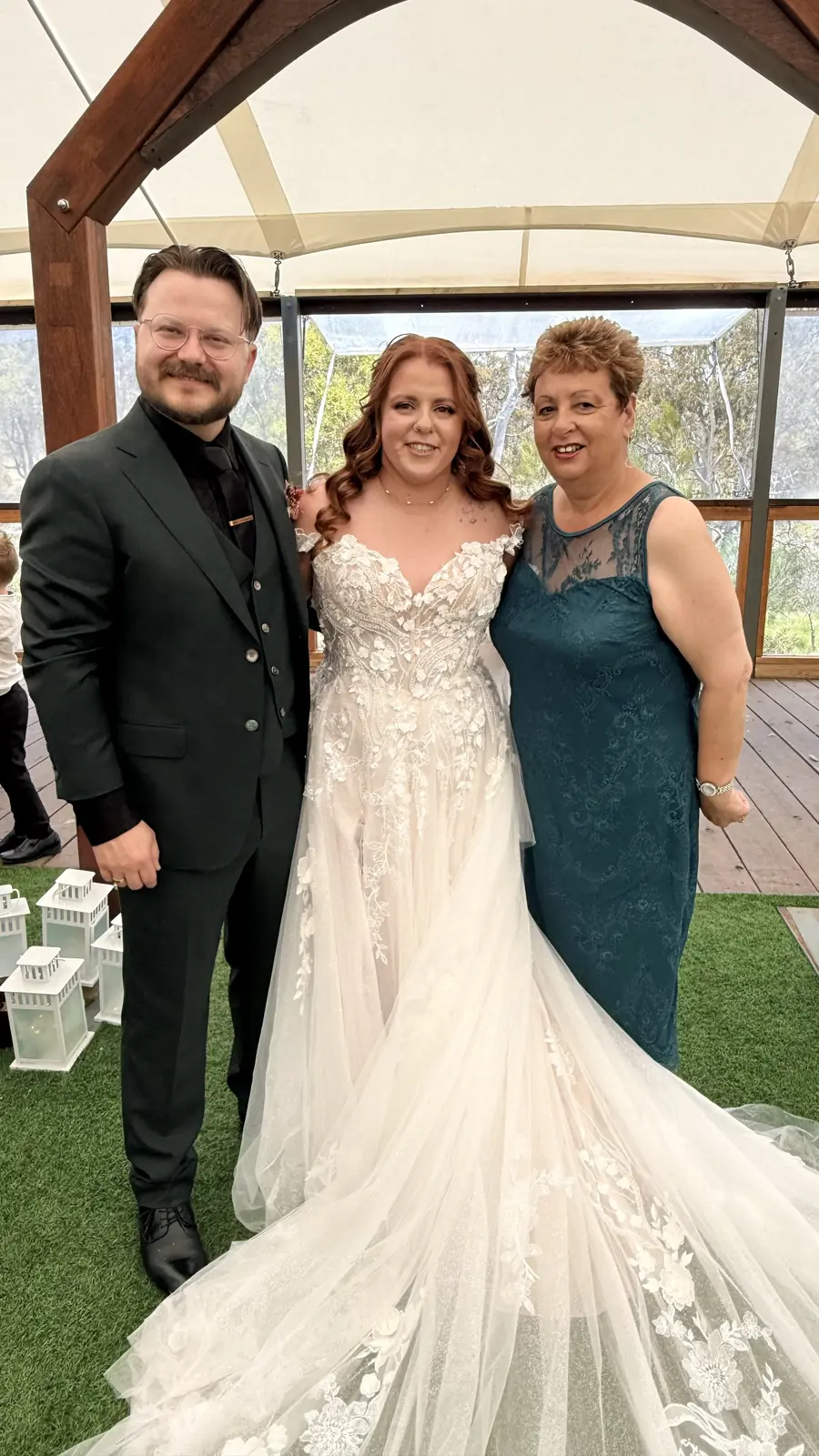 Josie with a bride and groom under a timber pavilion